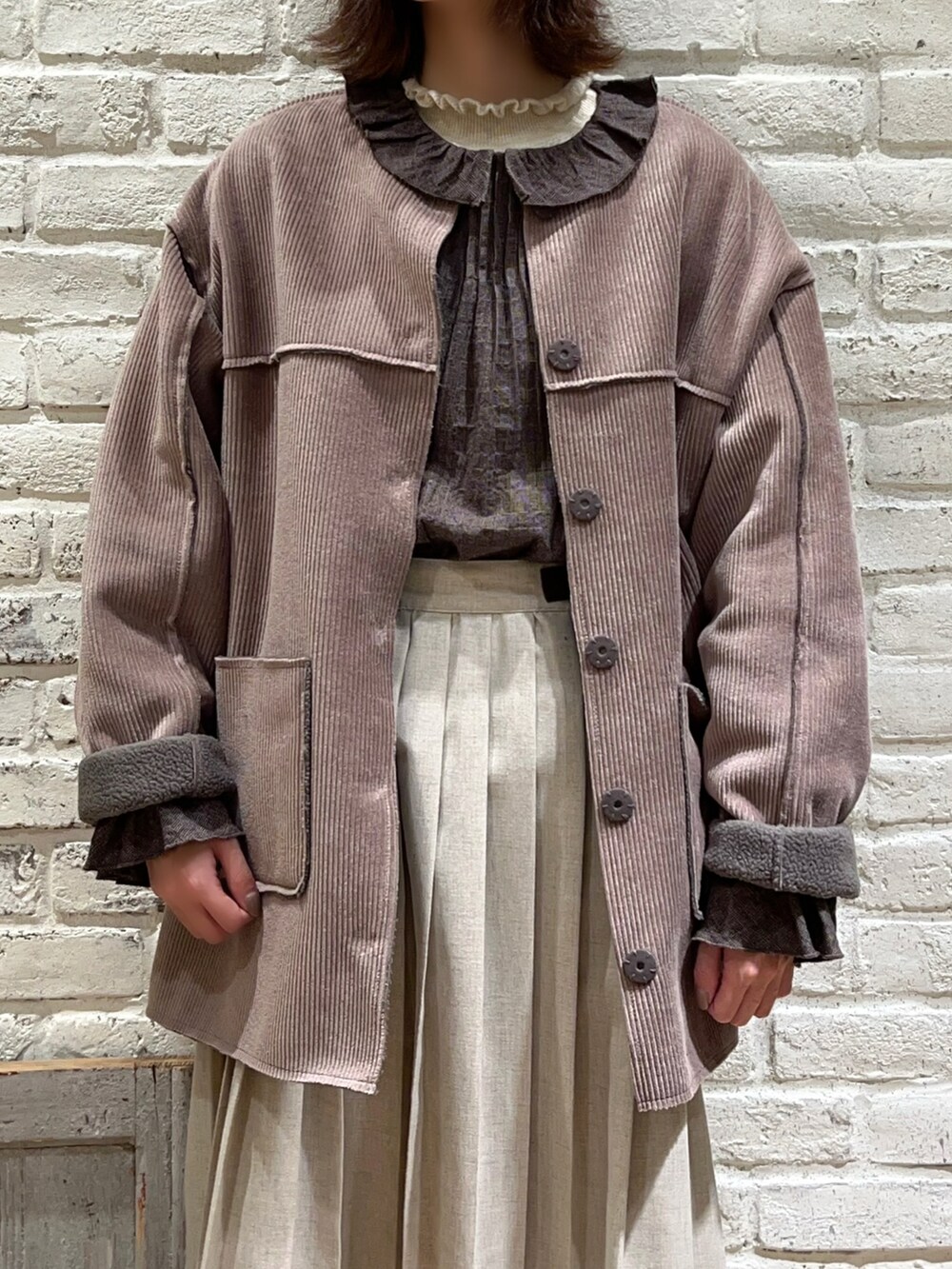 ホワイト系のニット/セーター、グレー系のシャツ/ブラウス、ブラウン系のその他アウターを着用したレディースの冬コーディネートの2枚目の写真