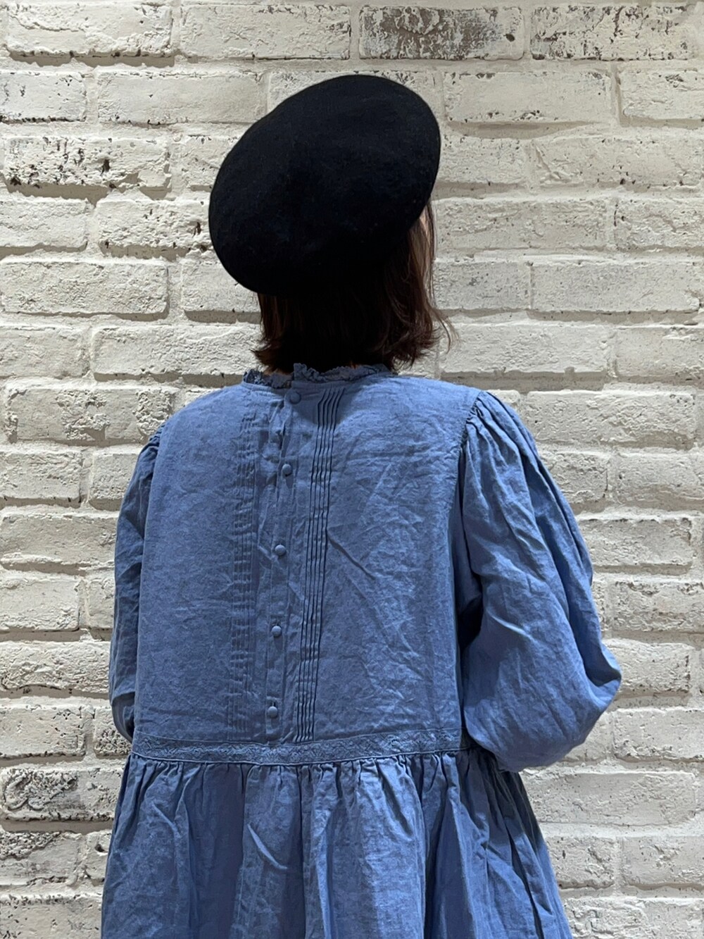 ブルー系のワンピース、ホワイト系のスカート、ブラック系のシューズを着用したレディースの冬コーディネートの4枚目の写真