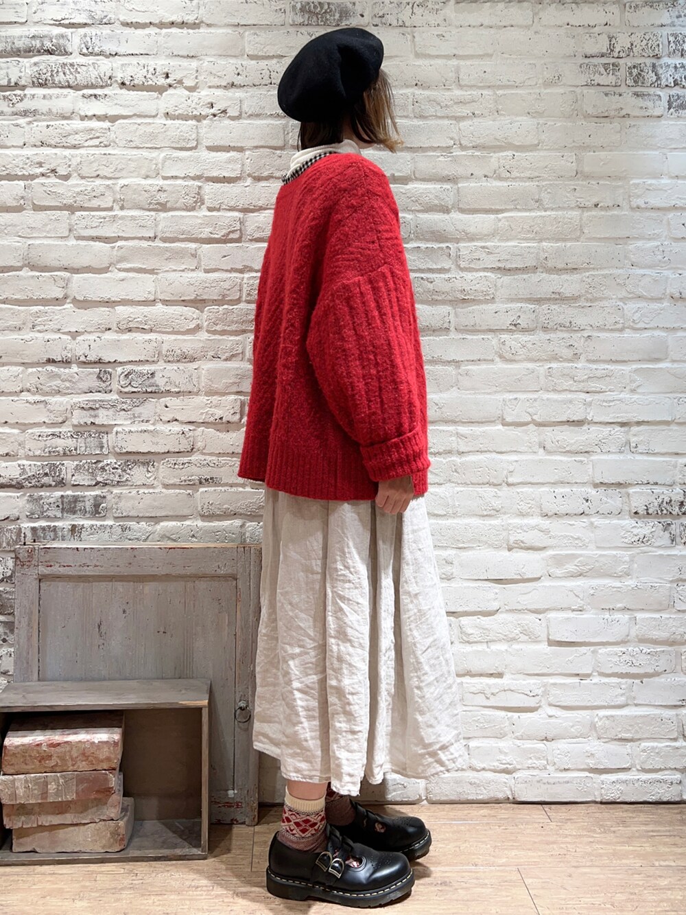 ホワイト系のニット/セーター、ブラック系のチュニック、レッド系のニット/セーターを着用したレディースの冬コーディネートの3枚目の写真