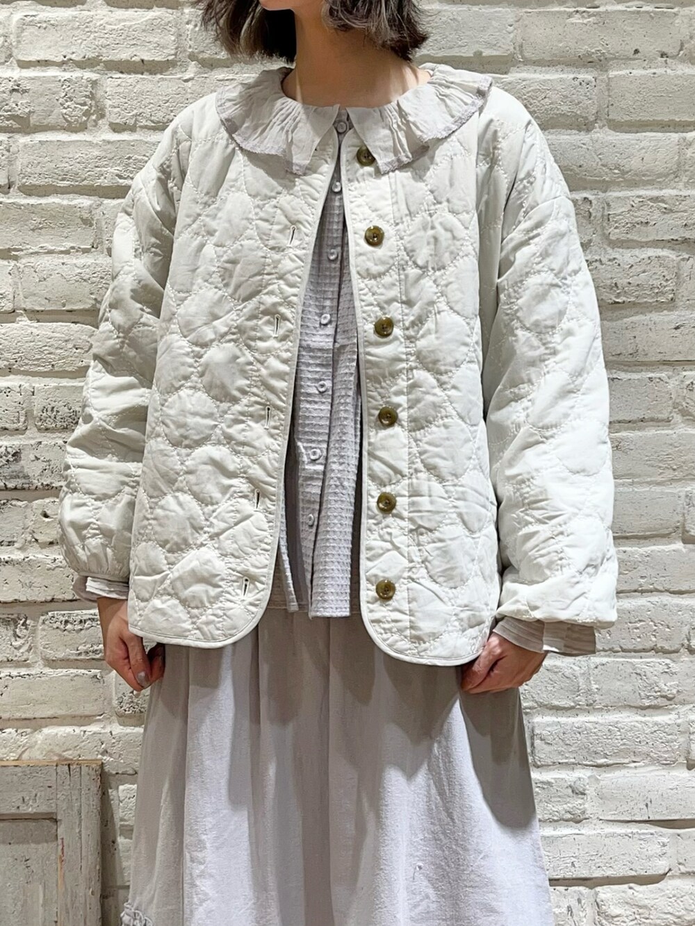 ホワイト系のノーカラージャケット、グレー系のシャツ/ブラウス、ブルー系のスカートを着用したレディースの冬コーディネートの2枚目の写真