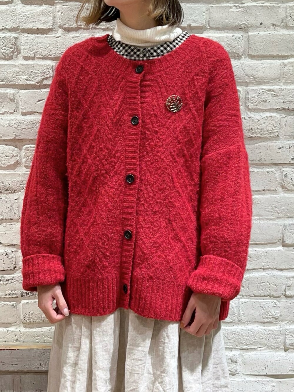 ホワイト系のニット/セーター、ブラック系のチュニック、レッド系のニット/セーターを着用したレディースの冬コーディネートの2枚目の写真