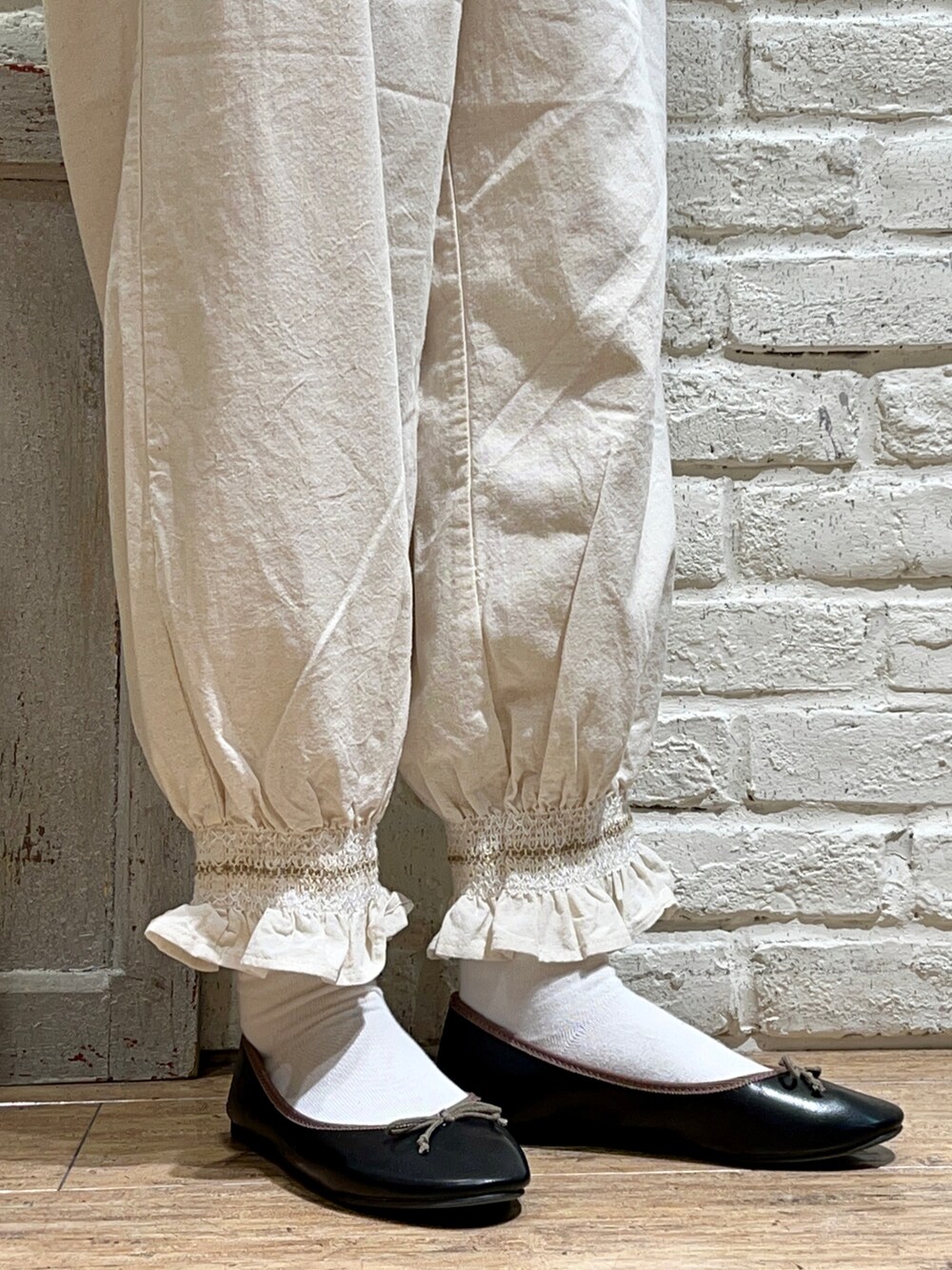 ブラック系のチュニック、ホワイト系のハンドバッグ、ホワイト系のその他パンツを着用したレディースの春コーディネートの5枚目の写真