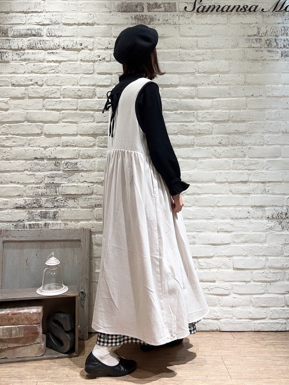 ブラック系のニット/セーター、ホワイト系のワンピース、ベージュ系のスカートを着用したレディースの冬コーディネートの3枚目の写真