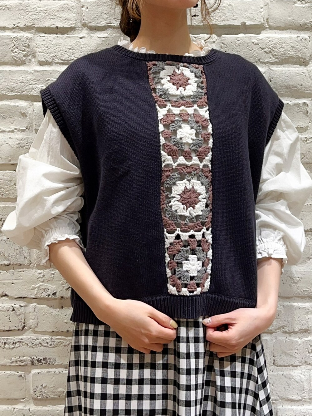 ブルー系のベスト、ホワイト系のシャツ/ブラウス、ブラック系のスカートを着用したレディースの春コーディネートの2枚目の写真