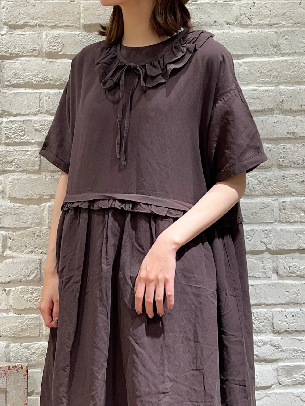 ベージュ系のワンピース、ブラック系のハンドバッグ、グレー系のワンピースを着用したレディースの春コーディネートの3枚目の写真