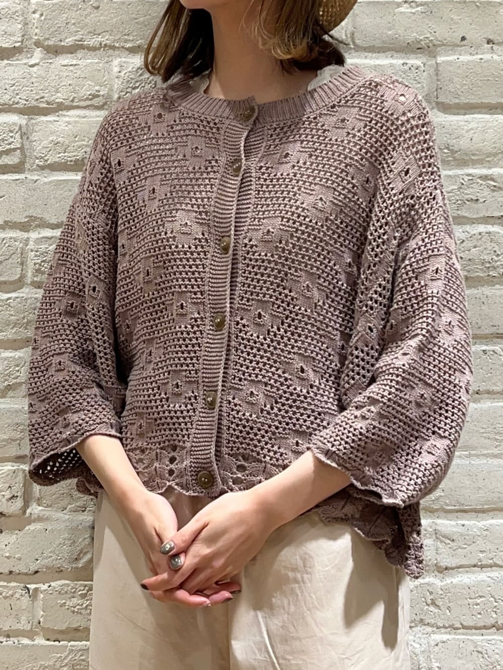 ベージュ系のタンクトップ、ブラウン系のカーディガン/ボレロ、ブラック系のハンドバッグを着用したレディースの春コーディネートの2枚目の写真