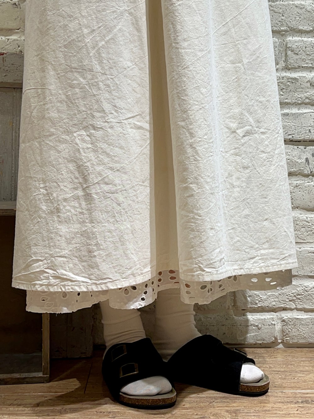 グレー系のTシャツ/カットソー、ブラック系のハンドバッグ、ホワイト系のワンピースを着用したレディースの秋コーディネートの5枚目の写真