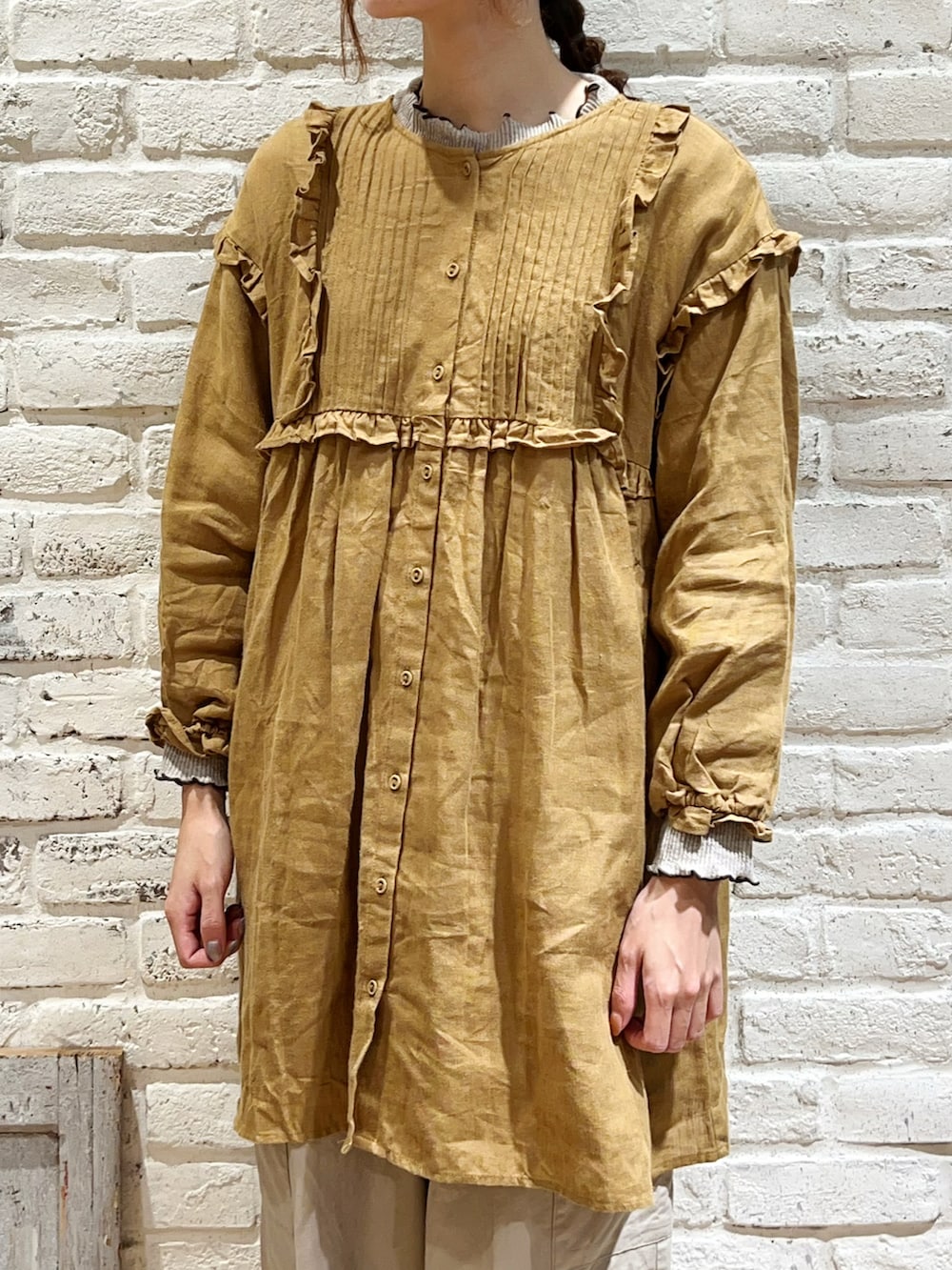 ベージュ系のTシャツ/カットソー、イエロー系のチュニック、ベージュ系のカーゴパンツを着用したレディースの冬コーディネートの2枚目の写真