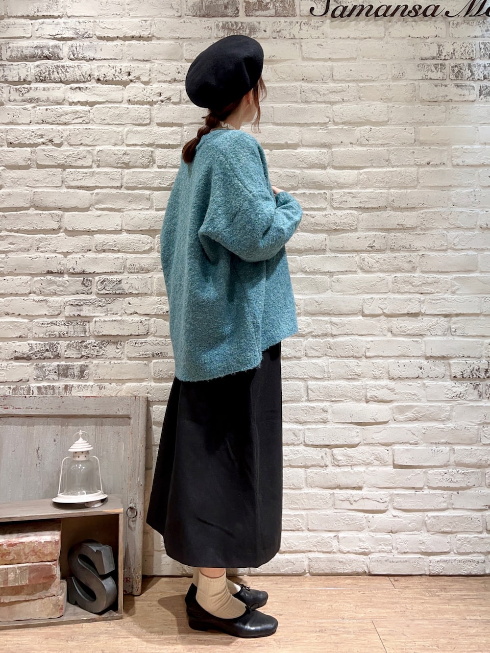 ホワイト系のニット/セーター、ブルー系のカーディガン/ボレロ、ブラック系のワンピースを着用したレディースの秋コーディネートの3枚目の写真