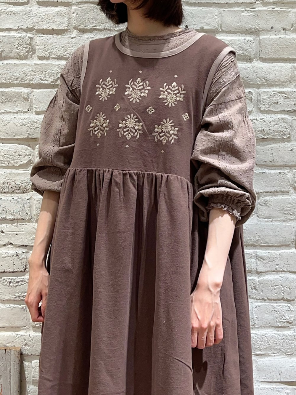 ブラウン系のワンピース、ブラウン系のワンピース、ブラウン系のハンドバッグを着用したレディースの冬コーディネートの2枚目の写真