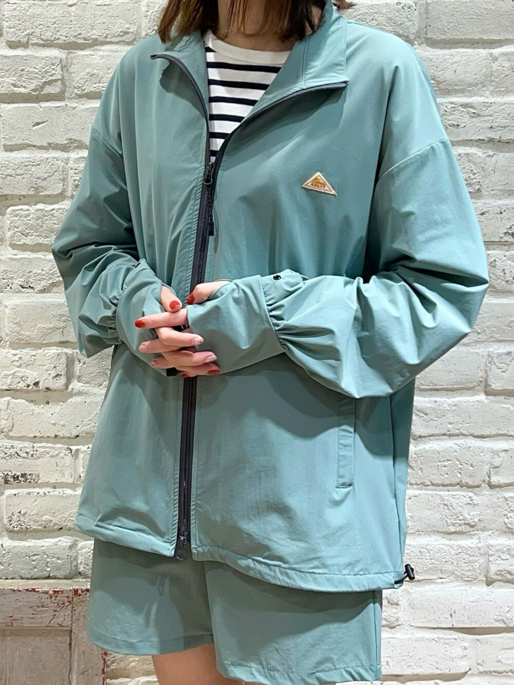 ホワイト系のタンクトップ、ホワイト系のTシャツ/カットソー、グリーン系のブルゾンを着用したレディースの春コーディネートの2枚目の写真