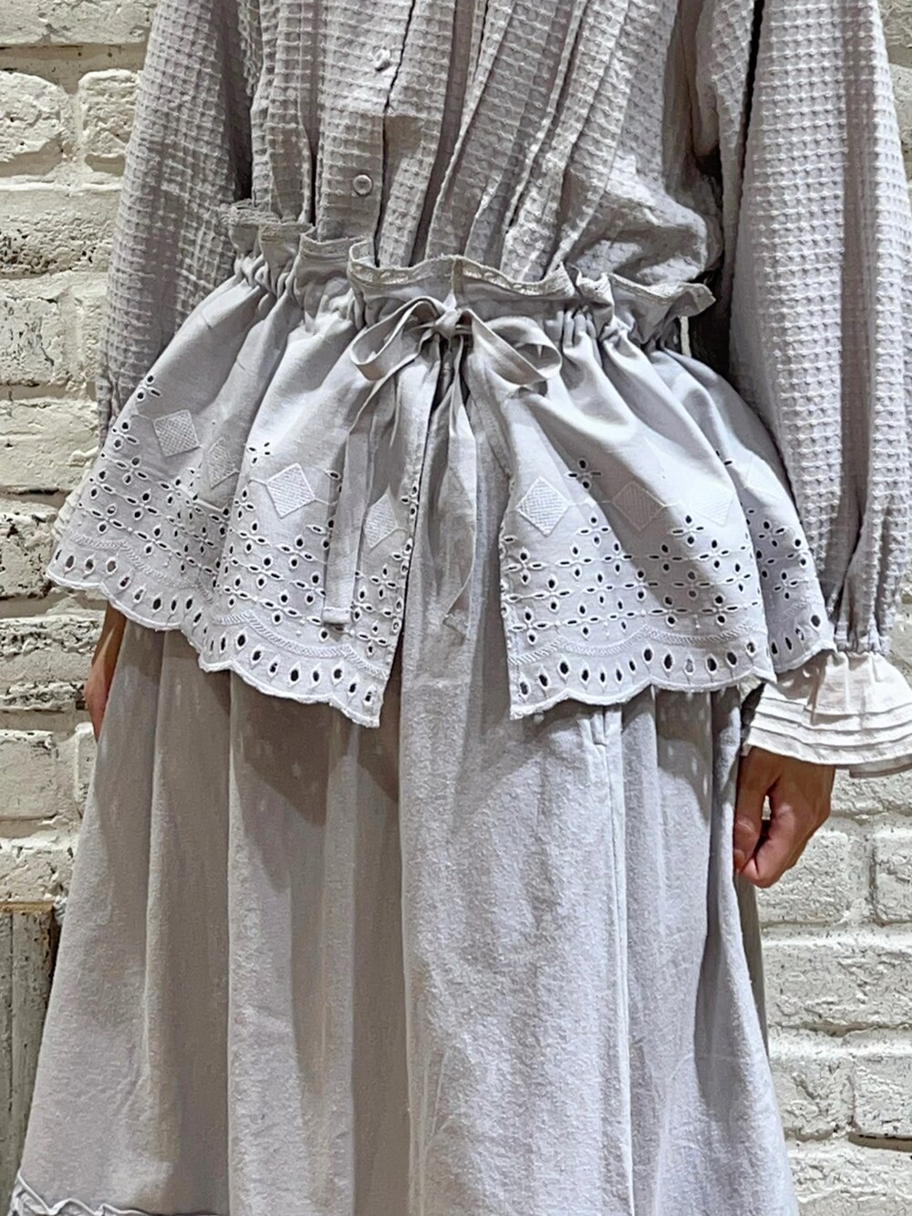 グレー系のシャツ/ブラウス、ブルー系のスカート、ホワイト系のブーツを着用したレディースの冬コーディネートの3枚目の写真