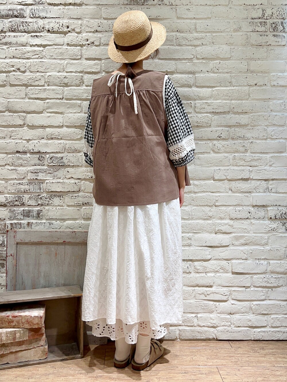 ブラウン系のベスト、ブラック系のシャツ/ブラウス、ホワイト系のワンピースを着用したレディースの夏コーディネートの4枚目の写真