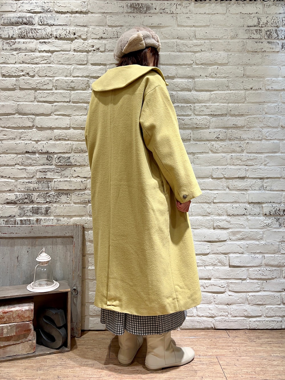 ベージュ系のチュニック、イエロー系のその他アウター、ホワイト系のブーツを着用したレディースの冬コーディネートの4枚目の写真