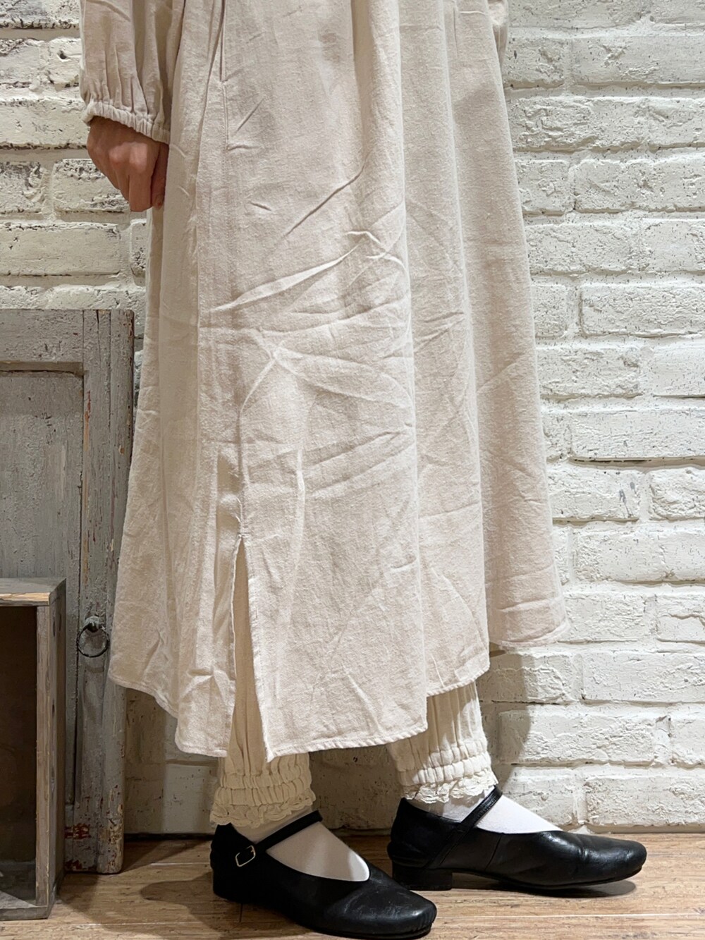 ホワイト系のニット/セーター、ホワイト系のワンピース、ベージュ系のカーディガン/ボレロを着用したレディースの冬コーディネートの5枚目の写真