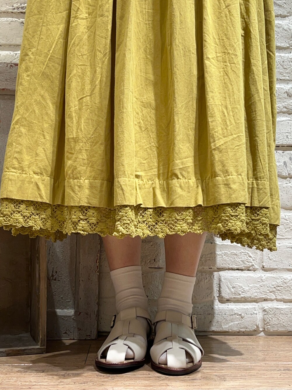 ホワイト系のタンクトップ、イエロー系のシャツ/ブラウス、グリーン系のワンピースを着用したレディースの春コーディネートの5枚目の写真