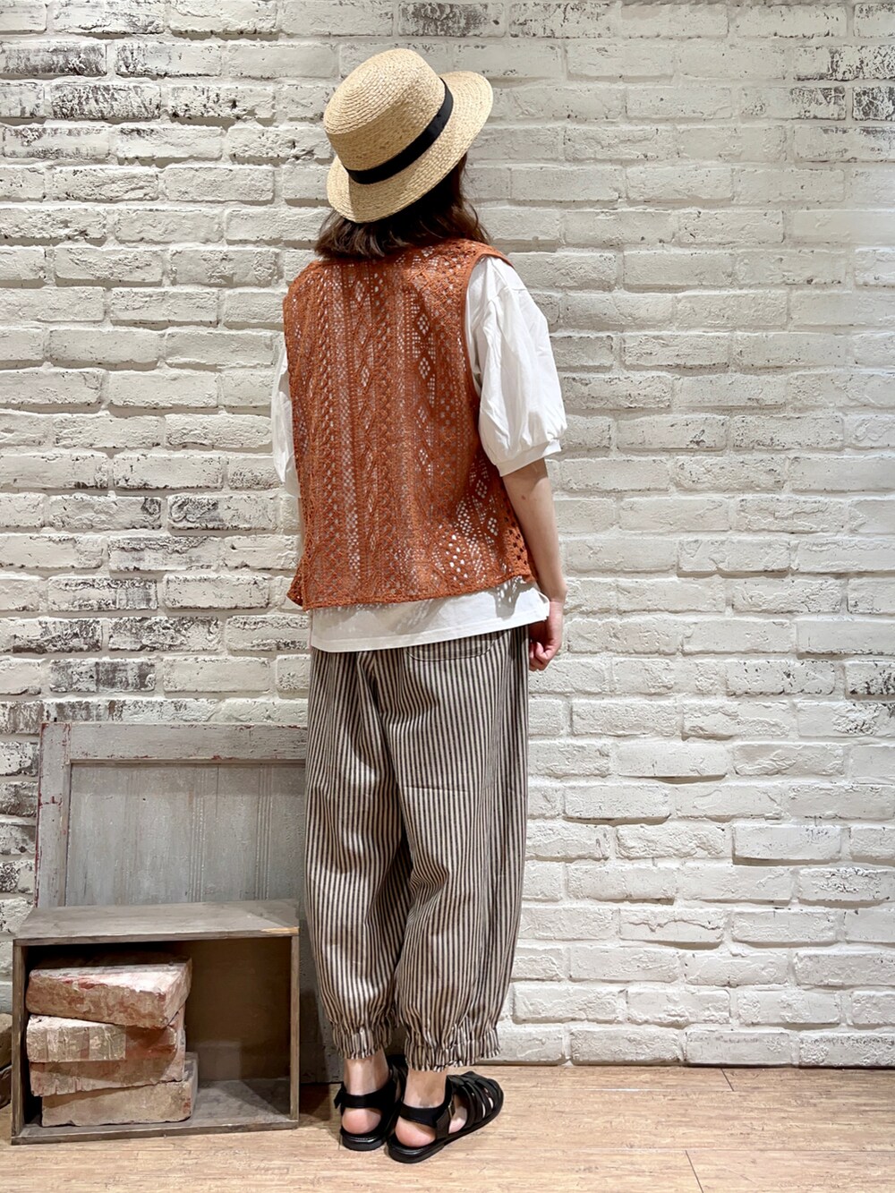 オレンジ系のTシャツ/カットソー、ホワイト系のハンドバッグ、ベージュ系のその他パンツを着用したレディースの秋コーディネートの4枚目の写真