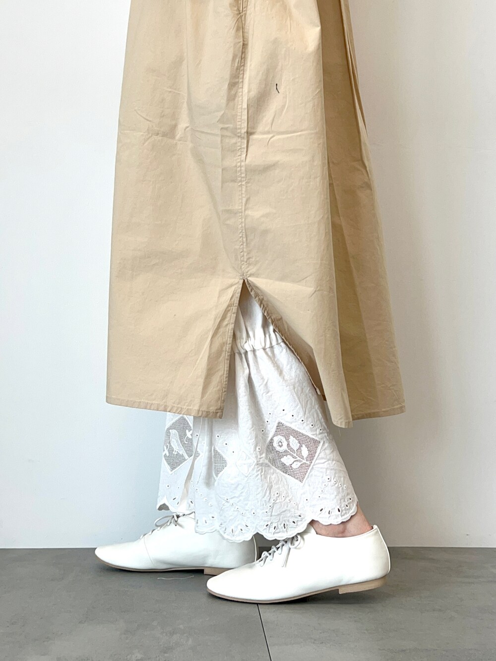 ホワイト系のベスト、ベージュ系のワンピース、ホワイト系のその他パンツを着用したレディースの春コーディネートの5枚目の写真