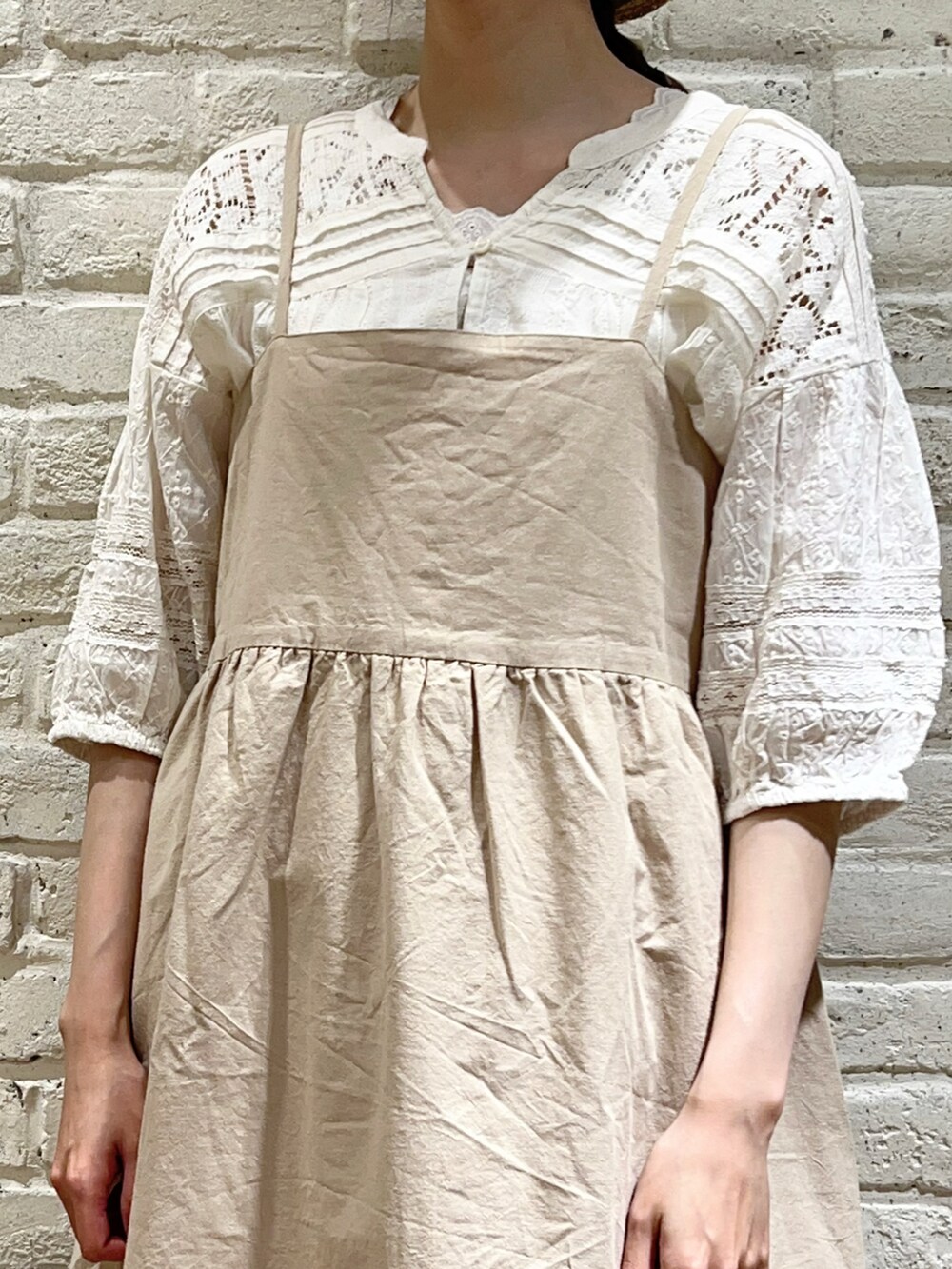 ホワイト系のタンクトップ、ホワイト系のシャツ/ブラウス、ベージュ系のハンドバッグを着用したレディースの夏コーディネートの2枚目の写真