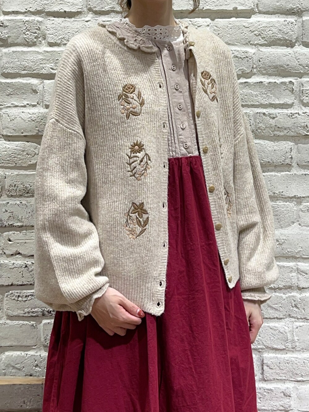 ホワイト系のTシャツ/カットソー、ベージュ系のカーディガン/ボレロ、レッド系のワンピースを着用したレディースの秋コーディネートの2枚目の写真