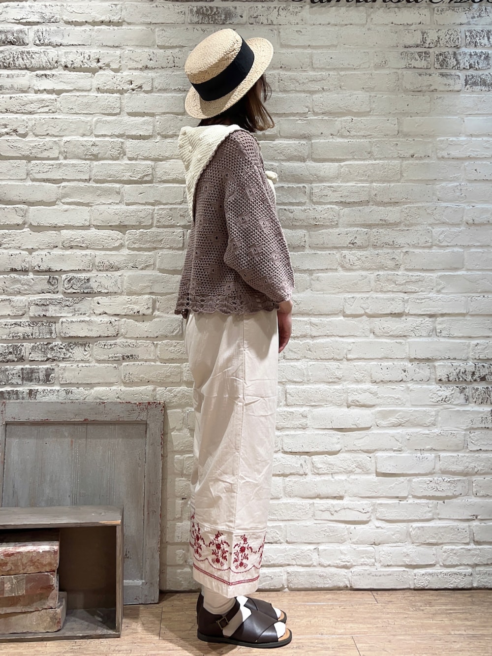 ベージュ系のタンクトップ、ブラウン系のカーディガン/ボレロ、ブラック系のハンドバッグを着用したレディースの春コーディネートの3枚目の写真