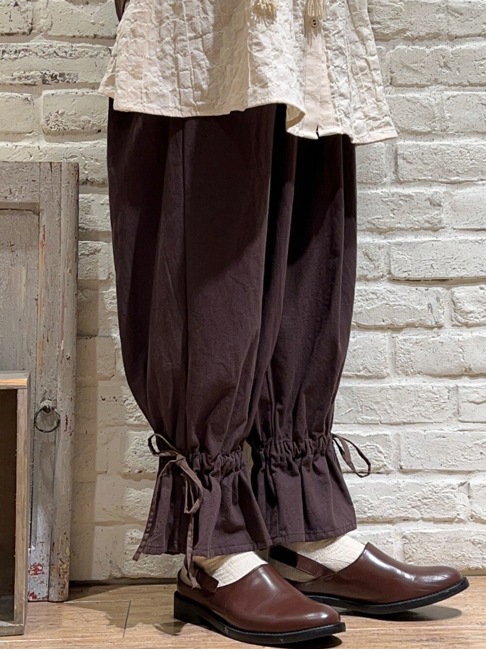 ブラウン系のベスト、ホワイト系のシャツ/ブラウス、ブラウン系のその他パンツを着用したレディースの秋コーディネートの5枚目の写真