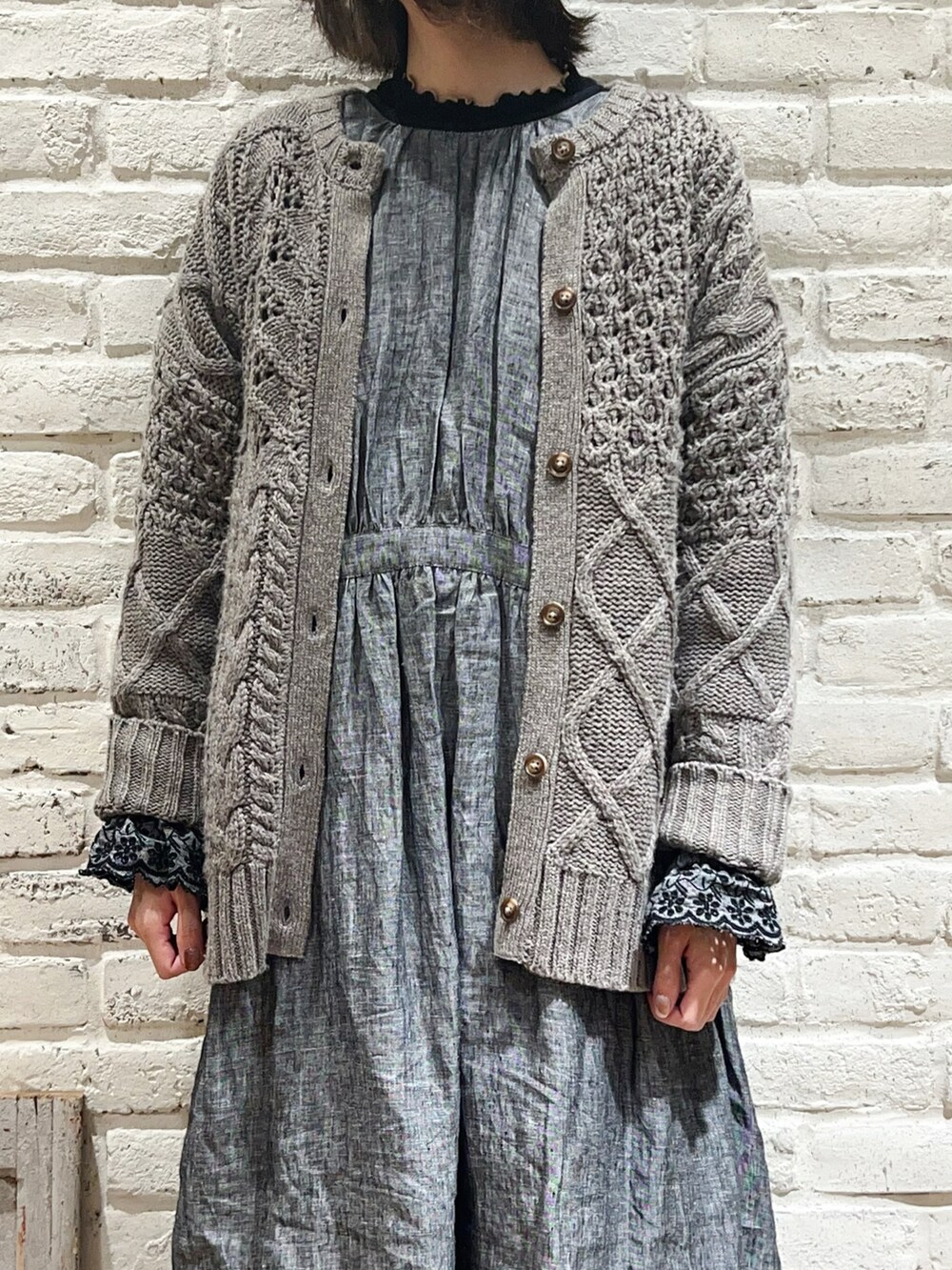 ブラック系のTシャツ/カットソー、ブラウン系のカーディガン/ボレロ、ブラック系のスカートを着用したレディースの冬コーディネートの2枚目の写真