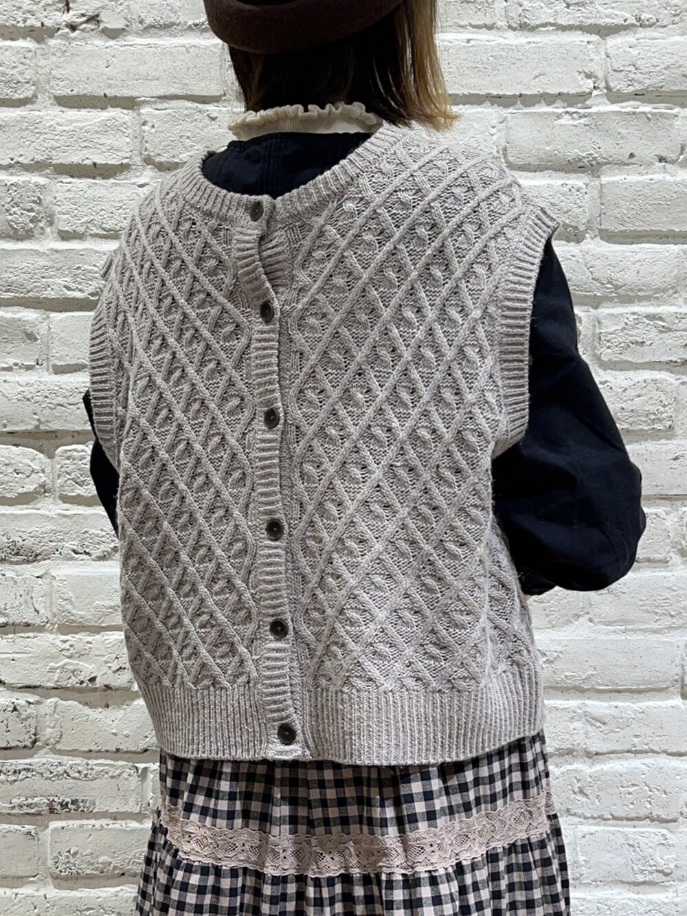 ホワイト系のニット/セーター、ベージュ系のベスト、ブラック系のシャツ/ブラウスを着用したレディースの秋コーディネートの5枚目の写真