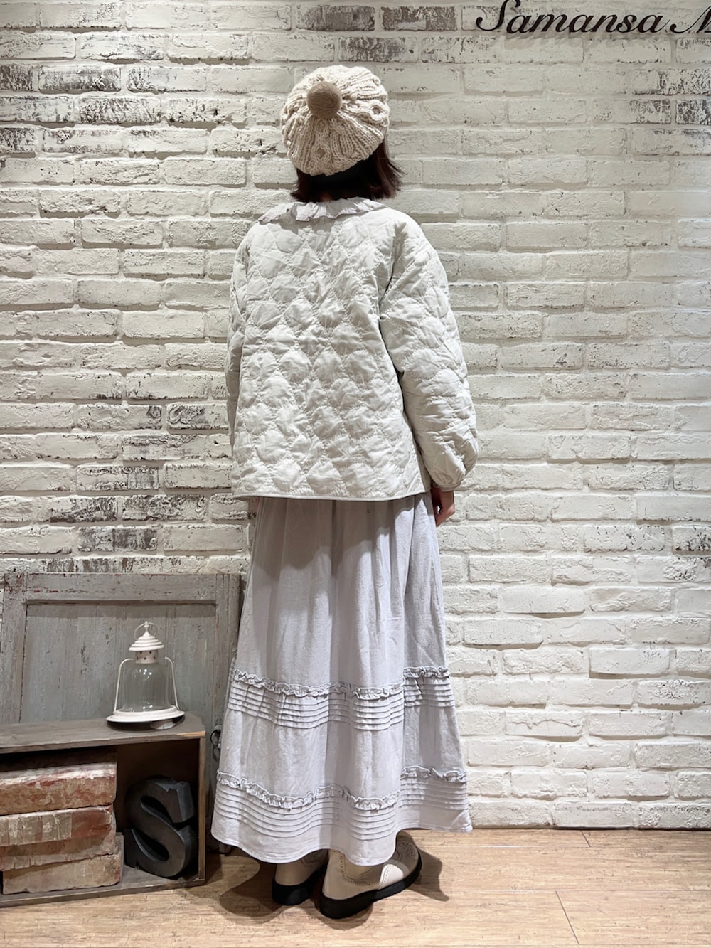 ホワイト系のノーカラージャケット、グレー系のシャツ/ブラウス、ブルー系のスカートを着用したレディースの冬コーディネートの5枚目の写真