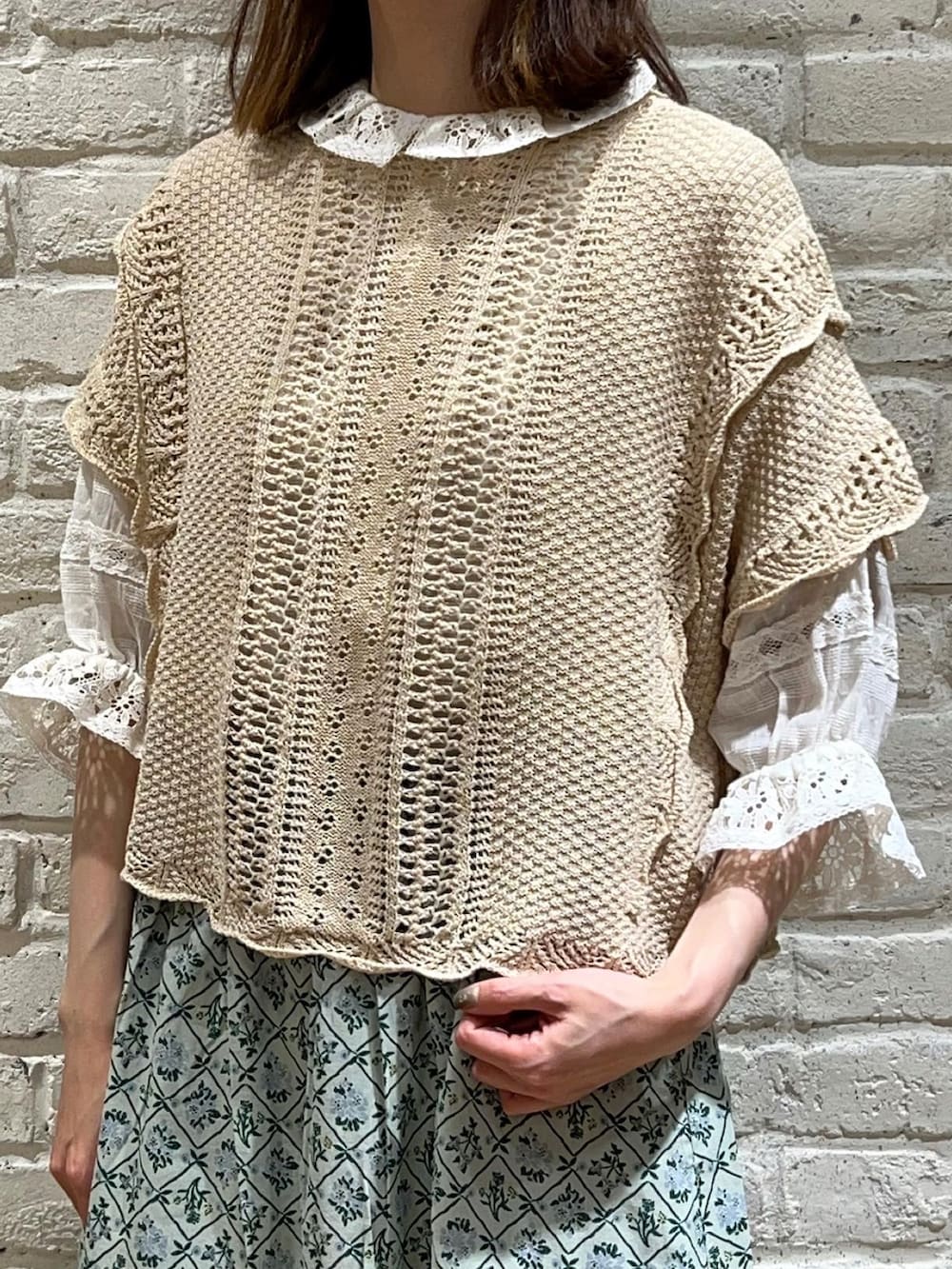 ホワイト系のシャツ/ブラウス、ホワイト系のベスト、グリーン系のスカートを着用したレディースの春コーディネートの2枚目の写真