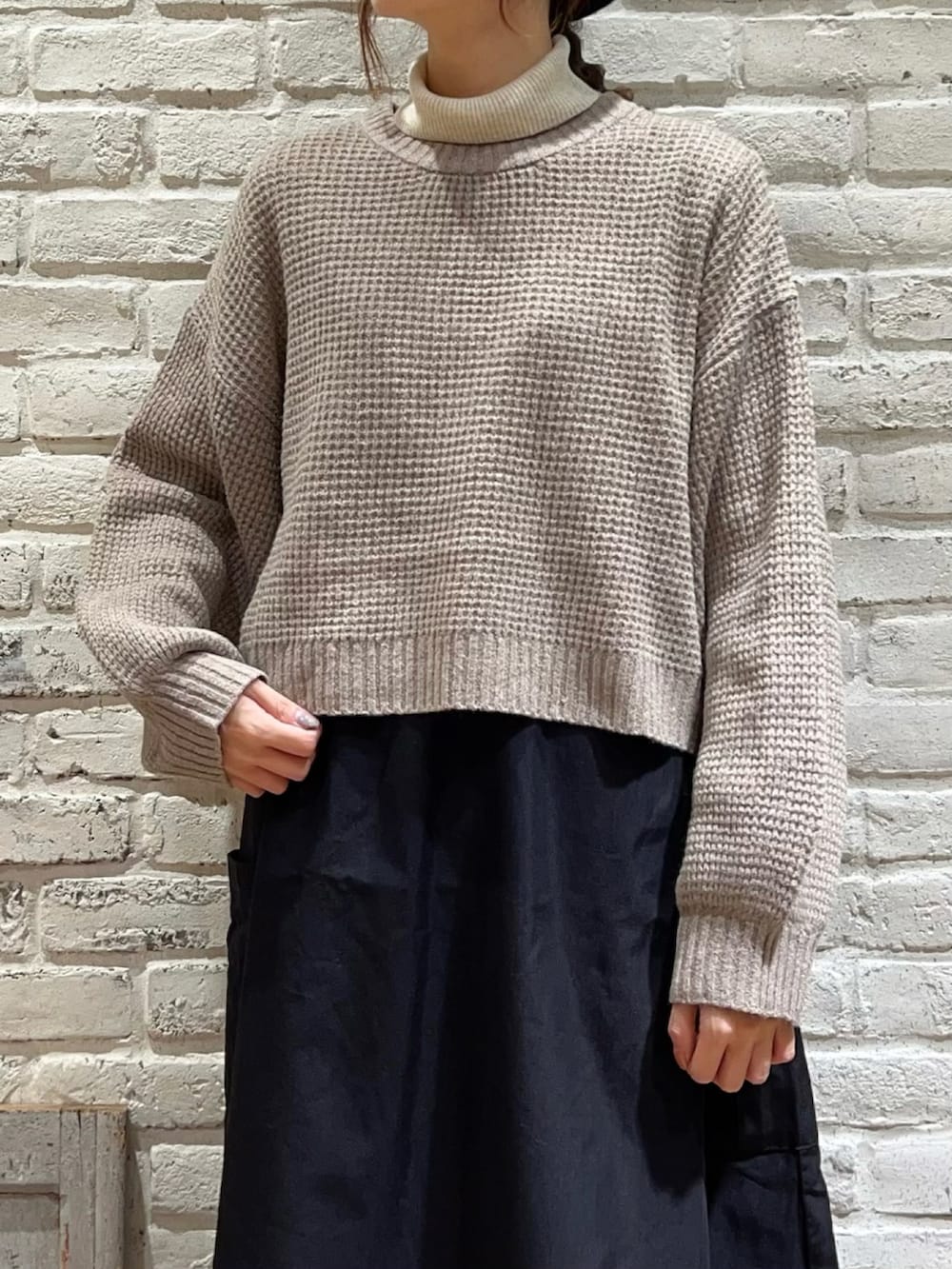 ホワイト系のニット/セーター、ブラック系のハンドバッグ、ブラック系のワンピースを着用したレディースの冬コーディネートの2枚目の写真