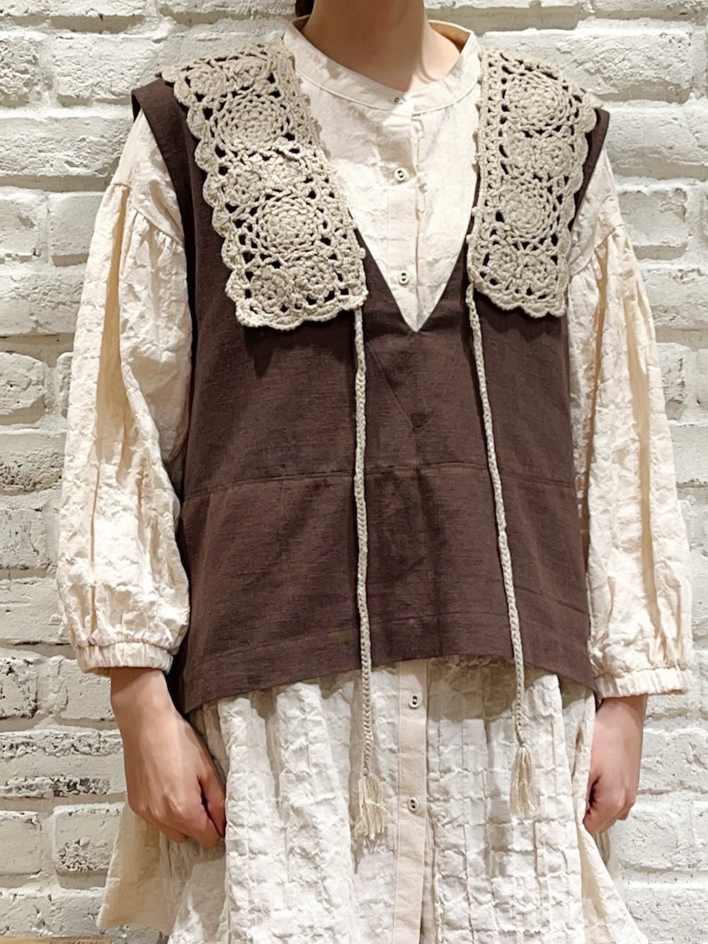 ブラウン系のベスト、ホワイト系のシャツ/ブラウス、ブラウン系のその他パンツを着用したレディースの秋コーディネートの2枚目の写真