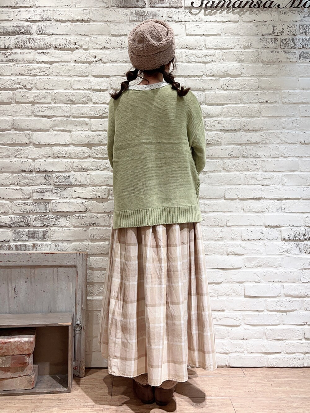 グリーン系のニット/セーター、ベージュ系のスカート、ブラウン系のブーツを着用したレディースの冬コーディネートの4枚目の写真