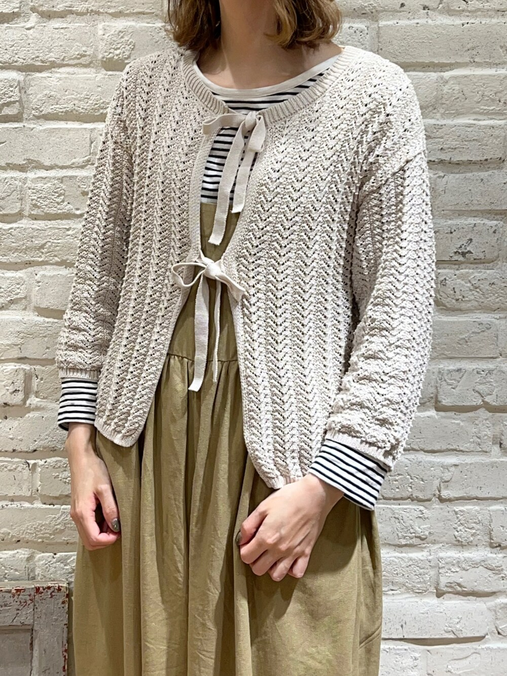 グレー系のTシャツ/カットソー、ホワイト系のカーディガン/ボレロ、ベージュ系のその他パンツを着用したレディースの春コーディネートの2枚目の写真