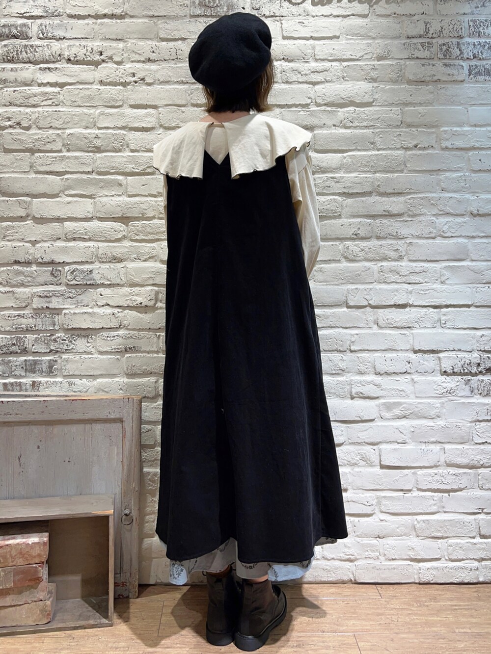 グレー系のTシャツ/カットソー、ブラック系のジャンパースカート、ブルー系のスカートを着用したレディースの秋コーディネートの4枚目の写真