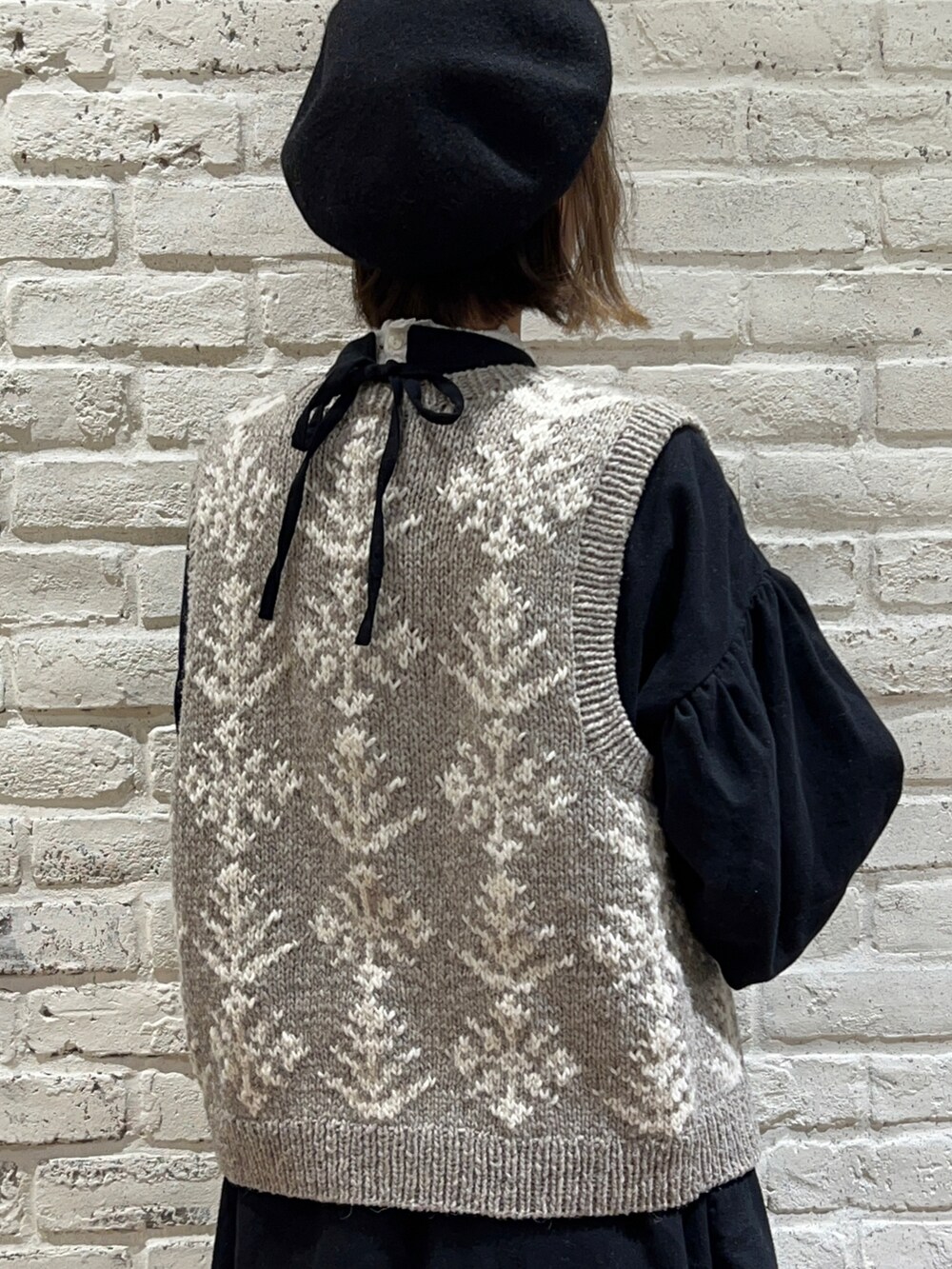 ホワイト系のTシャツ/カットソー、ブラウン系のベスト、ブラック系のワンピースを着用したレディースの冬コーディネートの4枚目の写真