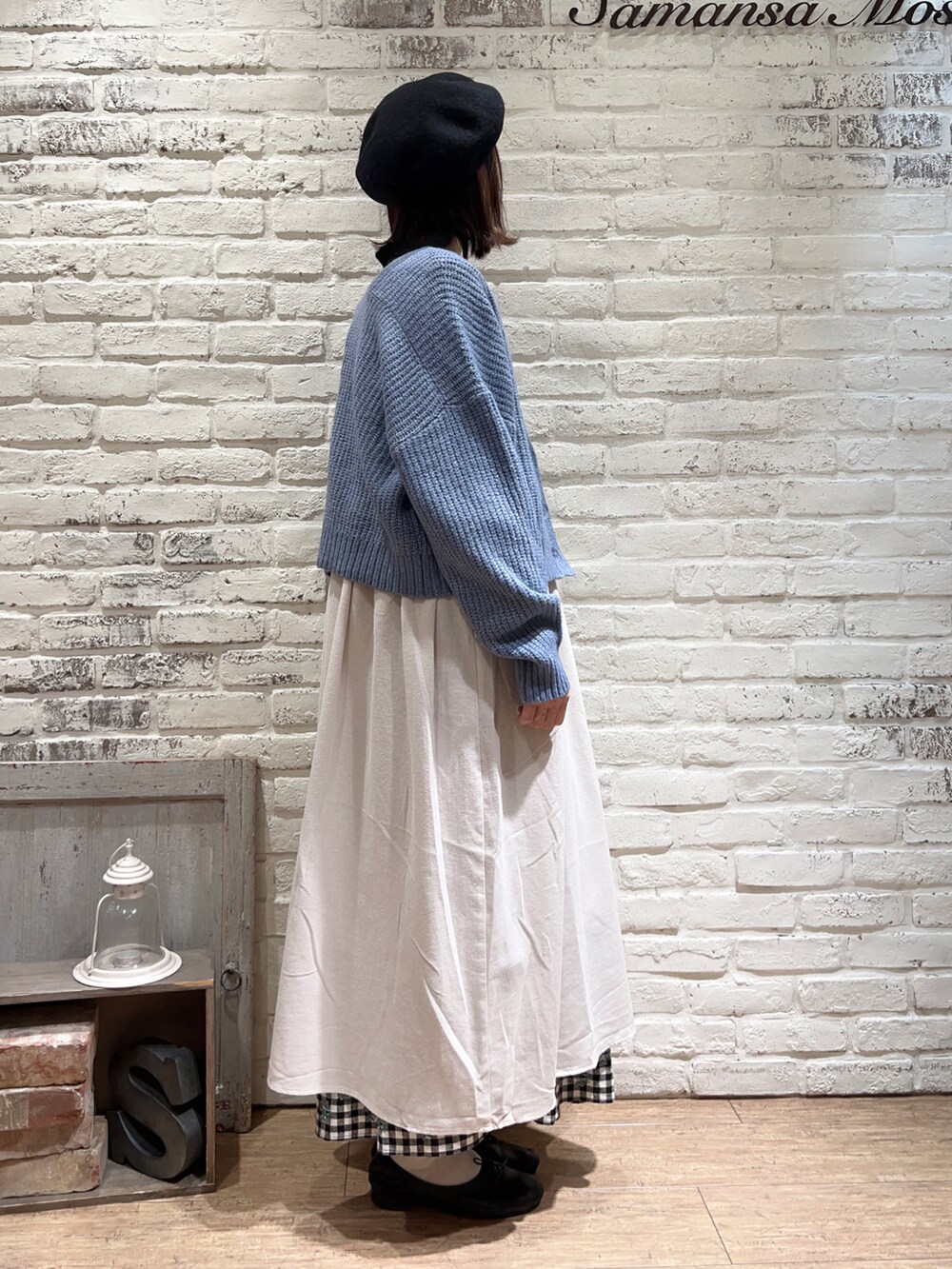 ブラック系のニット/セーター、ホワイト系のワンピース、ブルー系のカーディガン/ボレロを着用したレディースの冬コーディネートの4枚目の写真