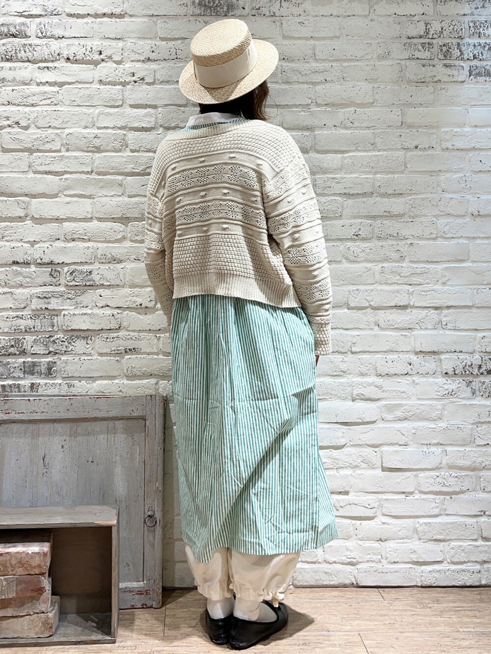 ホワイト系のニット/セーター、グリーン系のワンピース、ホワイト系のその他パンツを着用したレディースの冬コーディネートの4枚目の写真