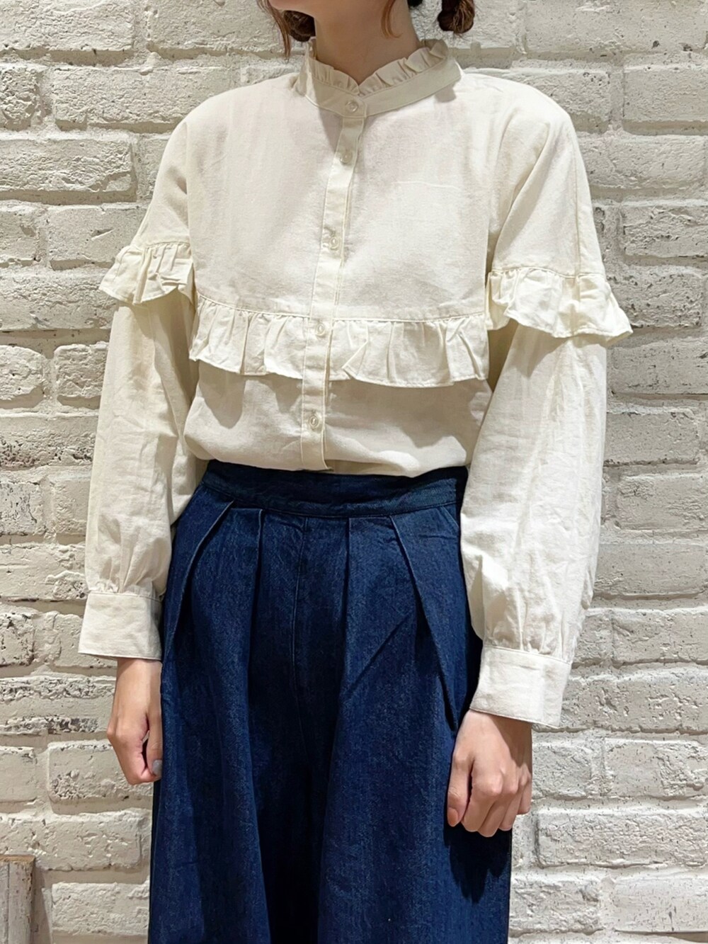 ホワイト系のシャツ/ブラウス、ブラック系のカーディガン/ボレロ、ブルー系のデニムパンツを着用したレディースの秋コーディネートの2枚目の写真