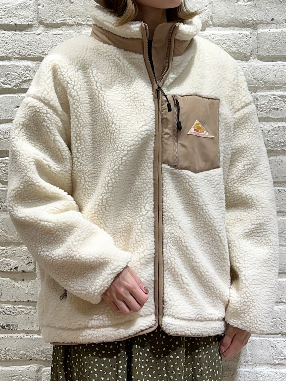 ブラック系のシャツ/ブラウス、ブラウン系のニット/セーター、ホワイト系のブルゾンを着用したレディースの秋コーディネートの2枚目の写真