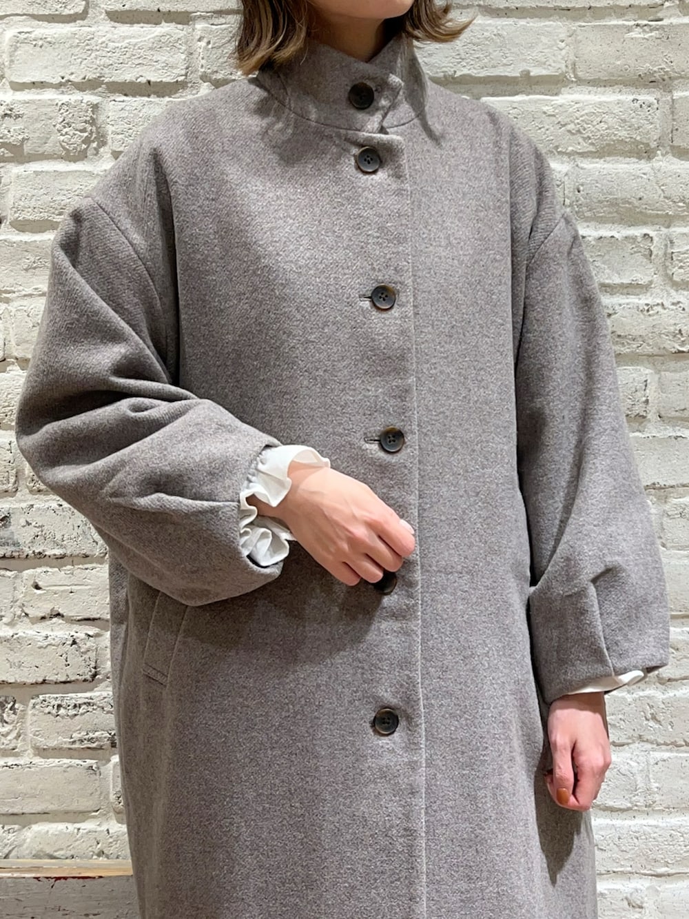 グレー系のその他アウター、ブラック系のベスト、ホワイト系のシャツ/ブラウスを着用したレディースの冬コーディネートの2枚目の写真