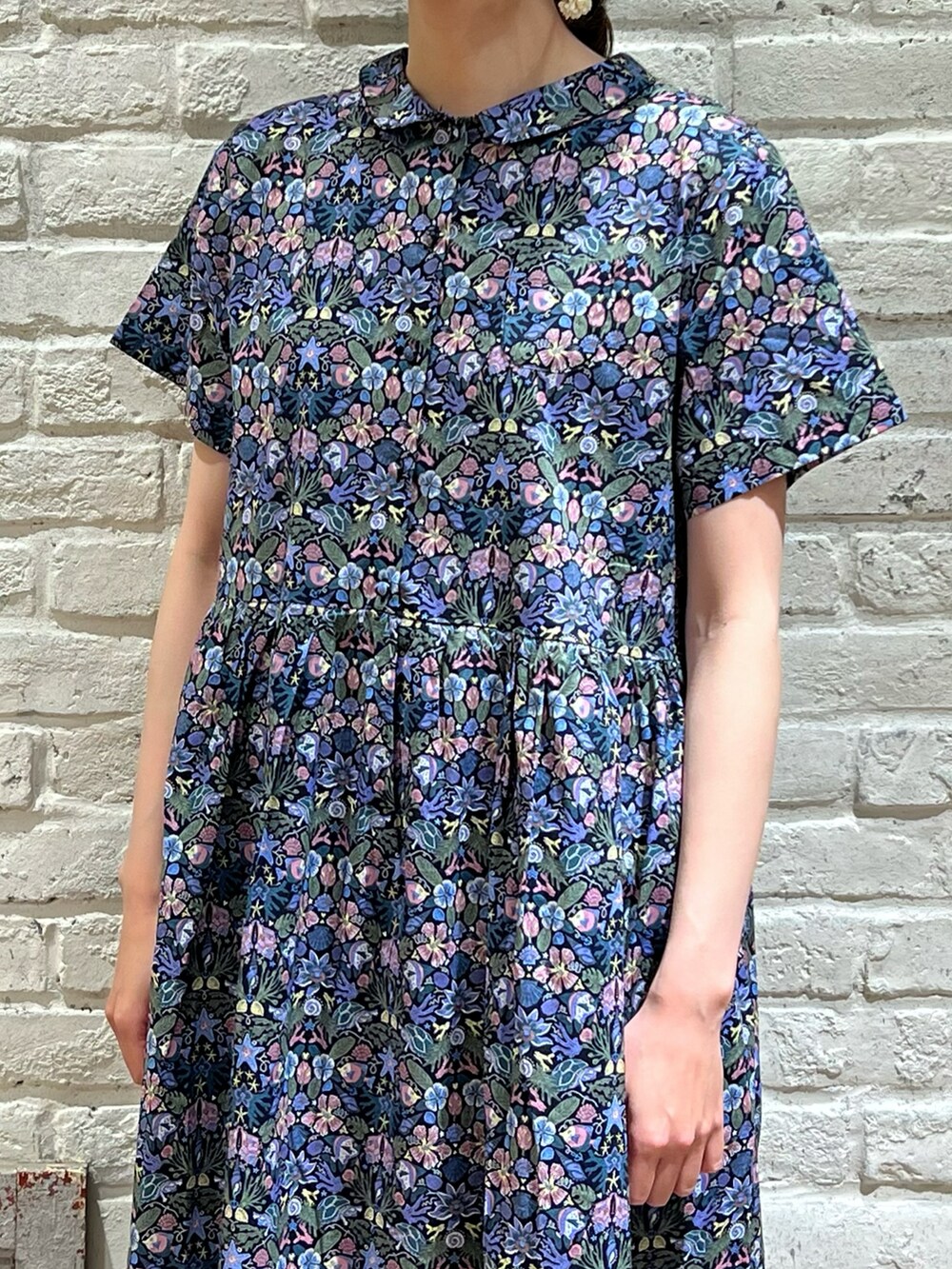 ホワイト系のニット/セーター、ブラック系のサンダル、ブルー系のワンピースを着用したレディースの春コーディネートの3枚目の写真