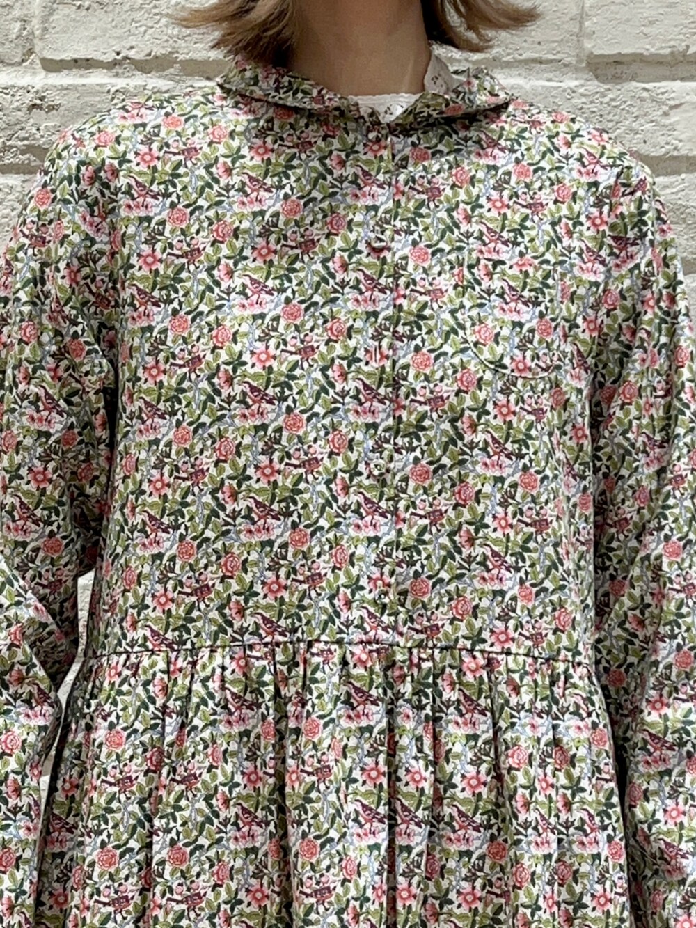 ピンク系のカーディガン/ボレロ、ピンク系のワンピース、ホワイト系のハットを着用したレディースの冬コーディネートの3枚目の写真