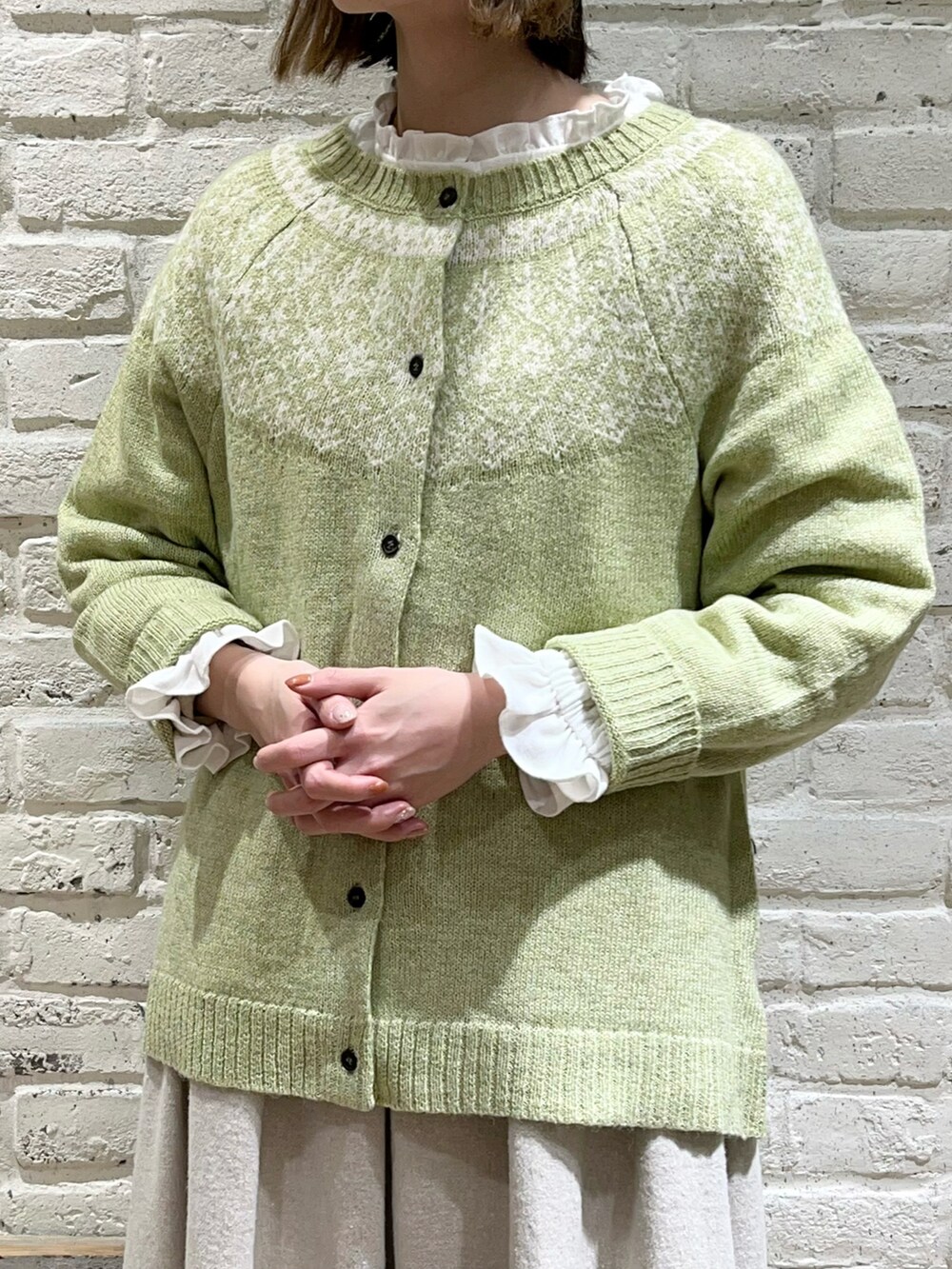 ホワイト系のシャツ/ブラウス、グリーン系のカーディガン/ボレロ、ホワイト系のその他アウターを着用したレディースの冬コーディネートの2枚目の写真