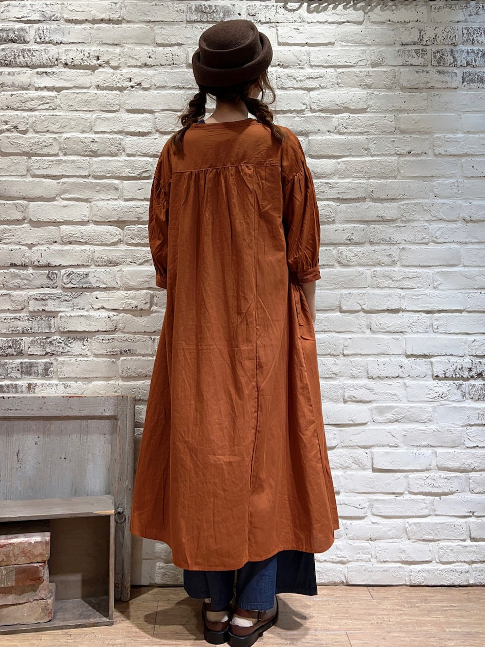 ベージュ系のTシャツ/カットソー、オレンジ系のワンピース、ブルー系のデニムパンツを着用したレディースの夏コーディネートの4枚目の写真