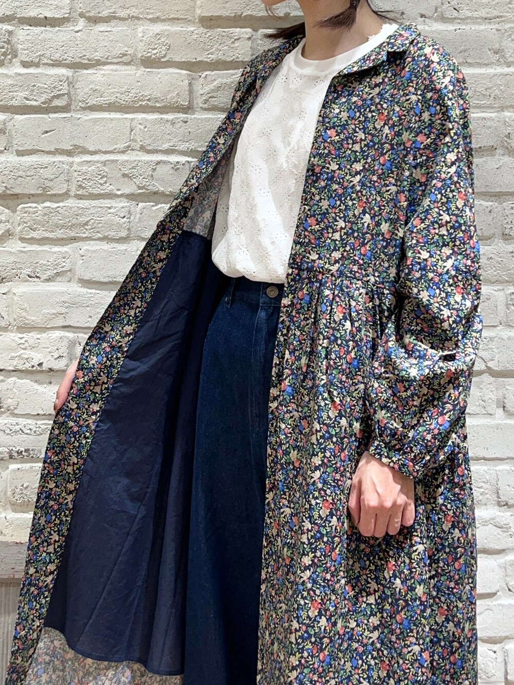 ホワイト系のTシャツ/カットソー、レッド系のワンピース、ブルー系のデニムパンツを着用したレディースの秋コーディネートの4枚目の写真