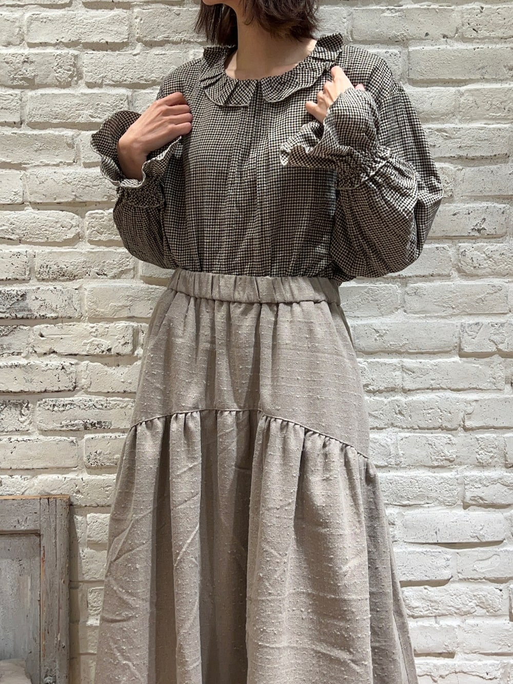 ブラウン系のシャツ/ブラウス、ブラック系のワンピース、ブラウン系のスカートを着用したレディースの冬コーディネートの3枚目の写真