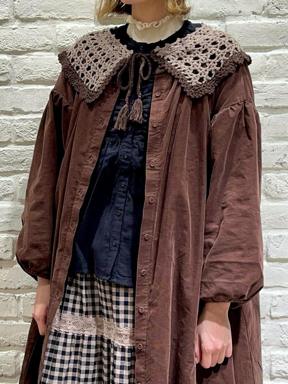 ホワイト系のニット/セーター、ブラック系のシャツ/ブラウス、ブラウン系のワンピースを着用したレディースの秋コーディネートの2枚目の写真