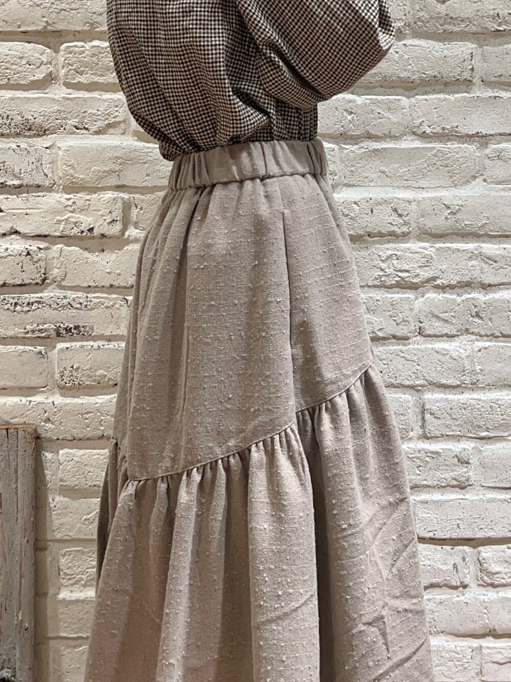 ブラウン系のシャツ/ブラウス、ブラック系のワンピース、ブラウン系のスカートを着用したレディースの冬コーディネートの4枚目の写真