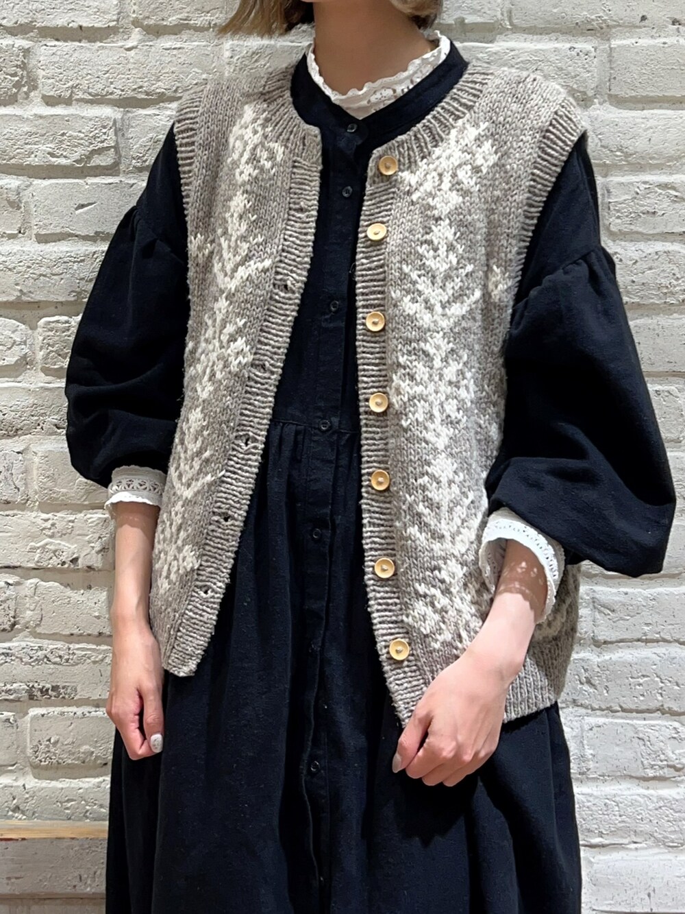 ホワイト系のTシャツ/カットソー、ブラウン系のベスト、ブラック系のワンピースを着用したレディースの冬コーディネートの2枚目の写真